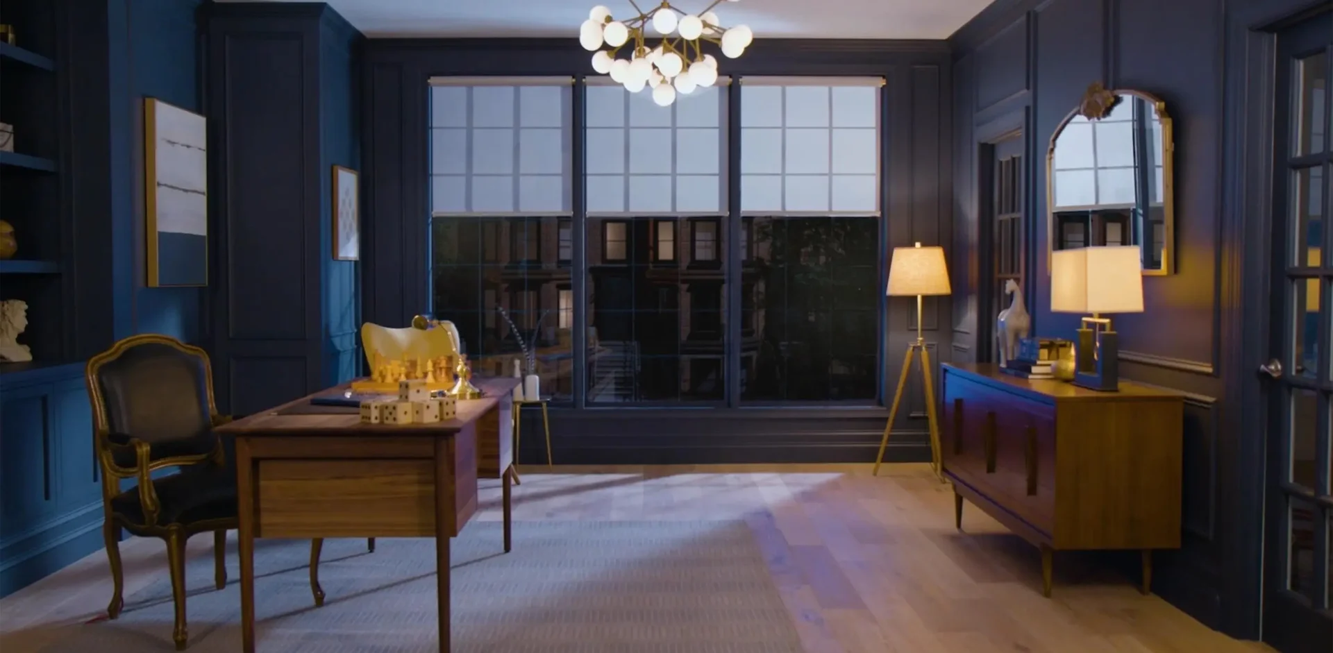 Lutron roller shades across three windows in a warmly lit home office