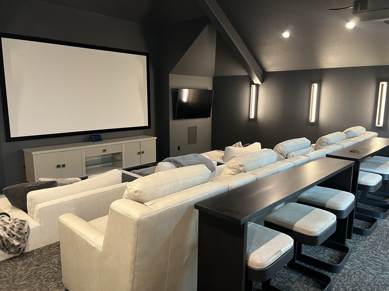 Dedicated home theater with a large projection screen and tiered seating in a Kingsland home