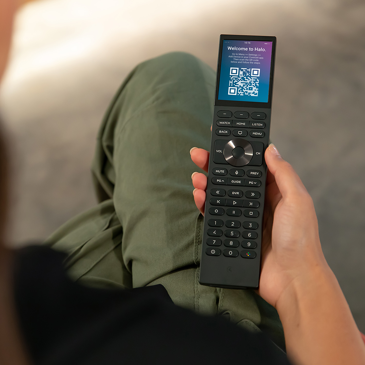 Red control4 neeo remote on black couch