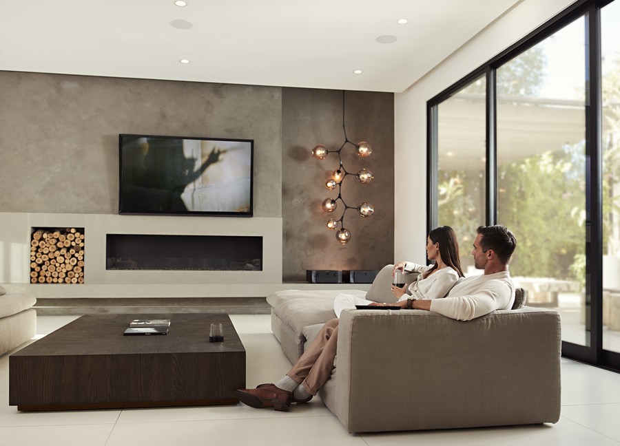 a couple sitting in a modern living room watching TV 