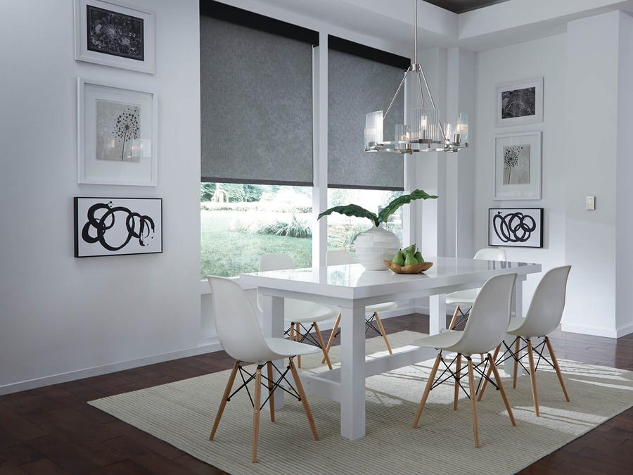 Modern dining room in Austin, TX, with stylish electric blinds partially drawn, allowing soft light in.