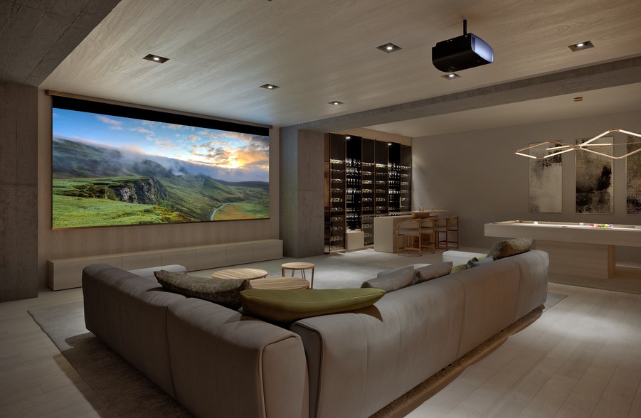 A casual home theater with a large screen, Sony projector, sectional, and pool table.
