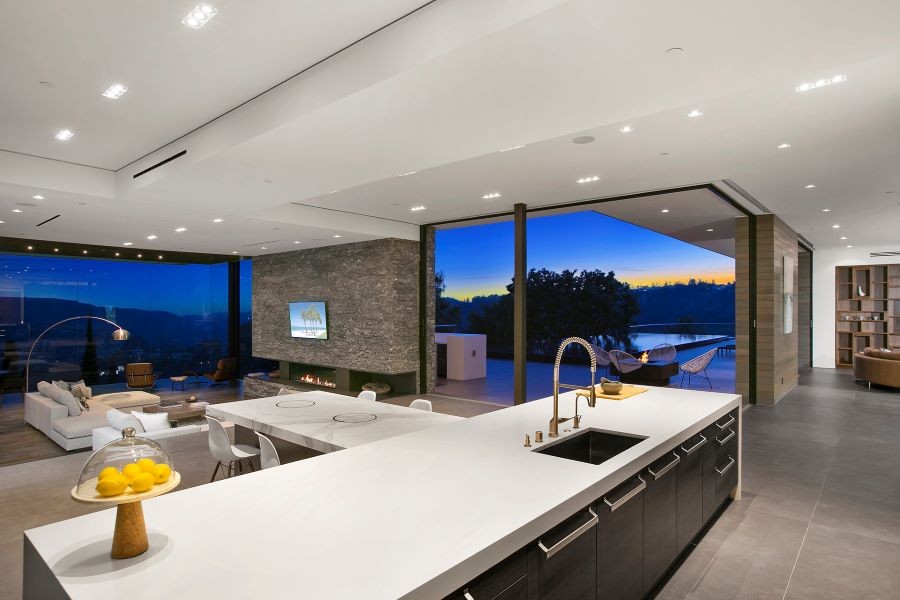A home with an open-floor plan, floor-to-ceiling windows, and in-ceiling speakers.