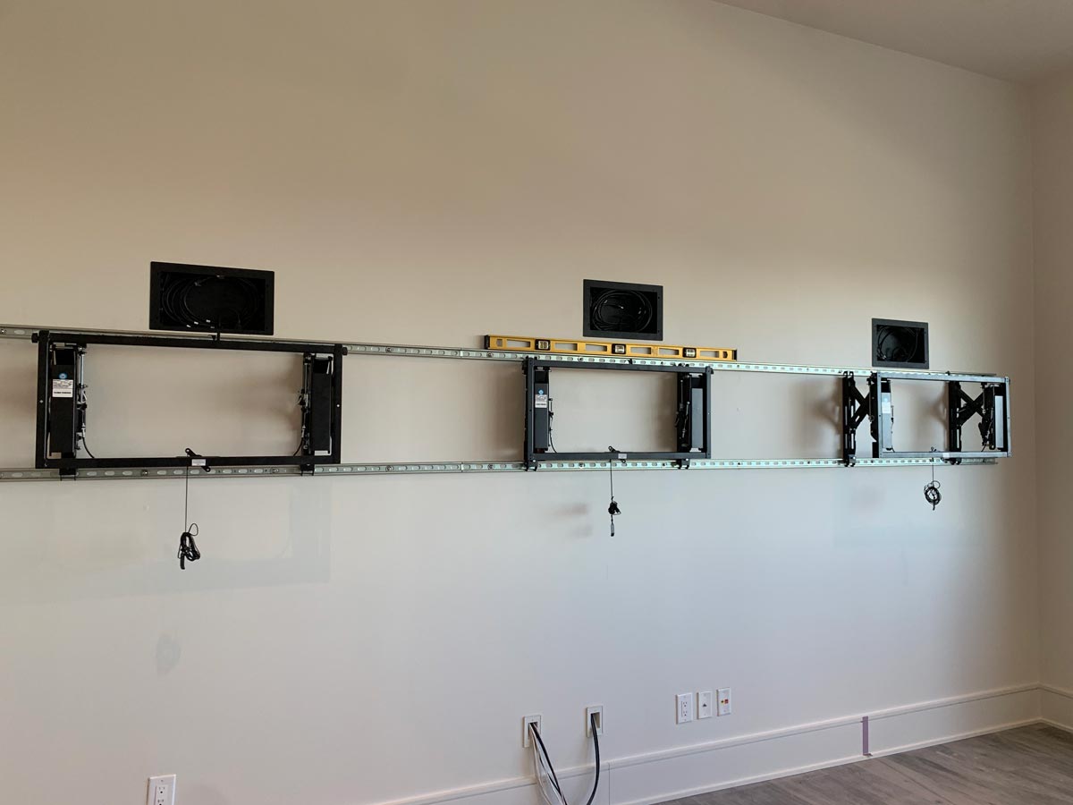 TV mounts set level across the media wall during installation