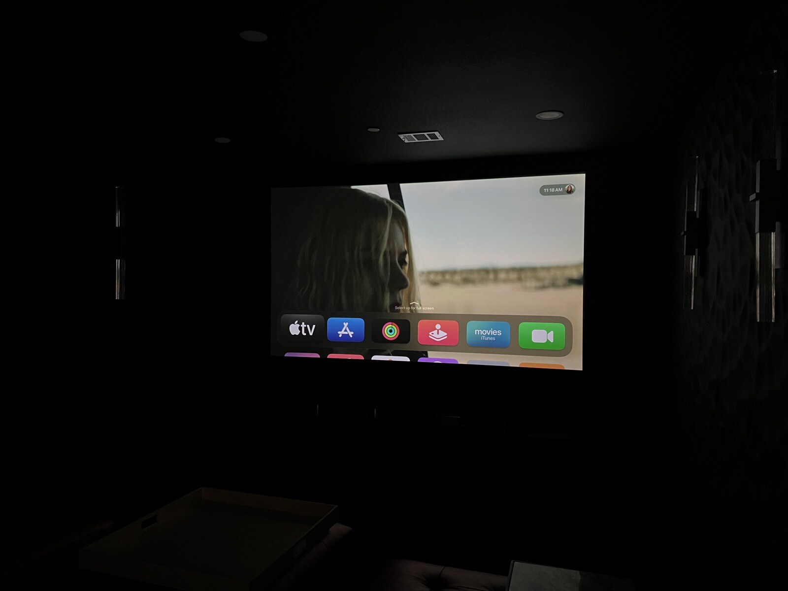 Angled view of a projection screen showing a streaming menu in a darkened theater