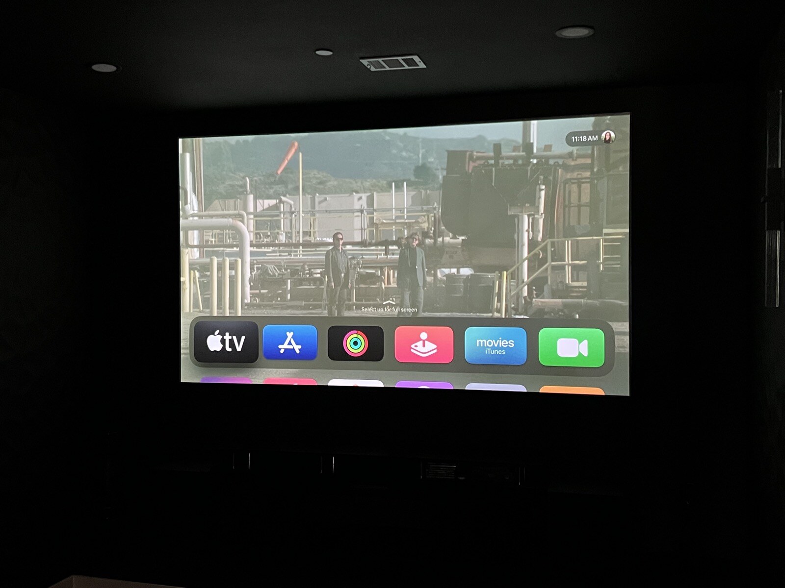 Front view of a streaming menu on a projection screen with the theater lights off