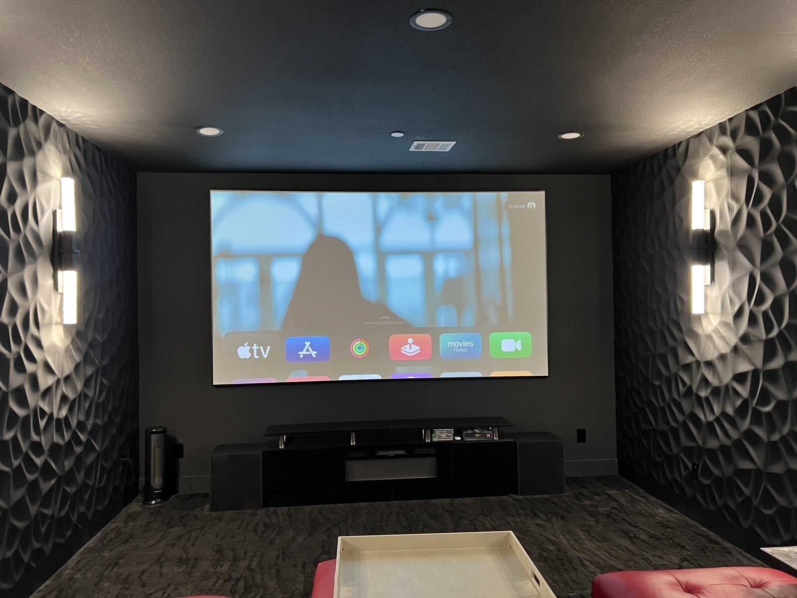 Projection screen showing a streaming menu between patterned walls and illuminated sconces