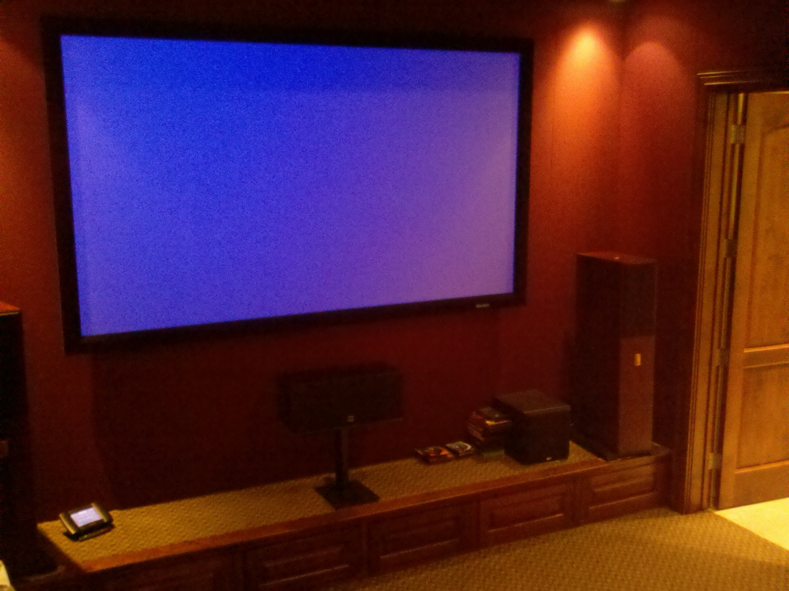Lake Austin home theater screen with center channel and tower speakers on the riser stage