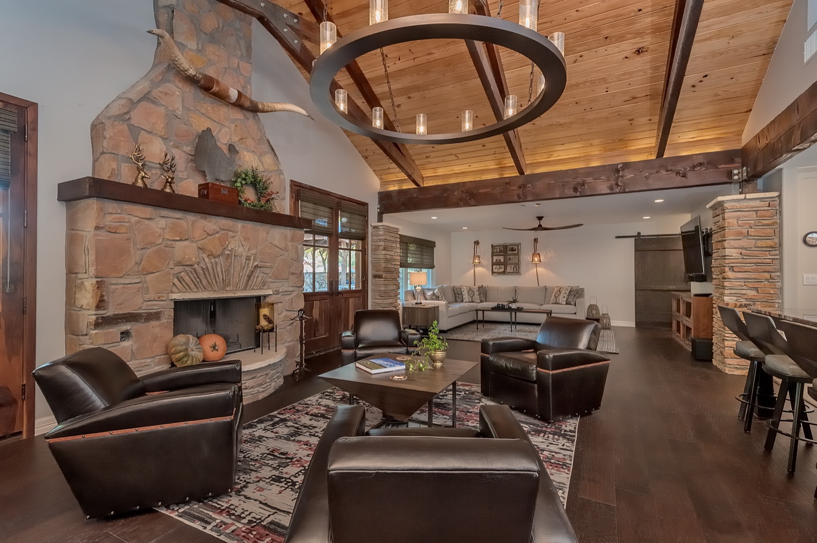 Sitting area by the stone fireplace with in-ceiling speakers in the wood ceiling