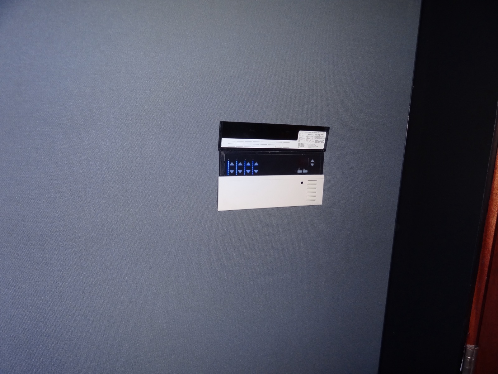 Lutron lighting control station recessed into a fabric-wrapped theater wall in Tarrytown