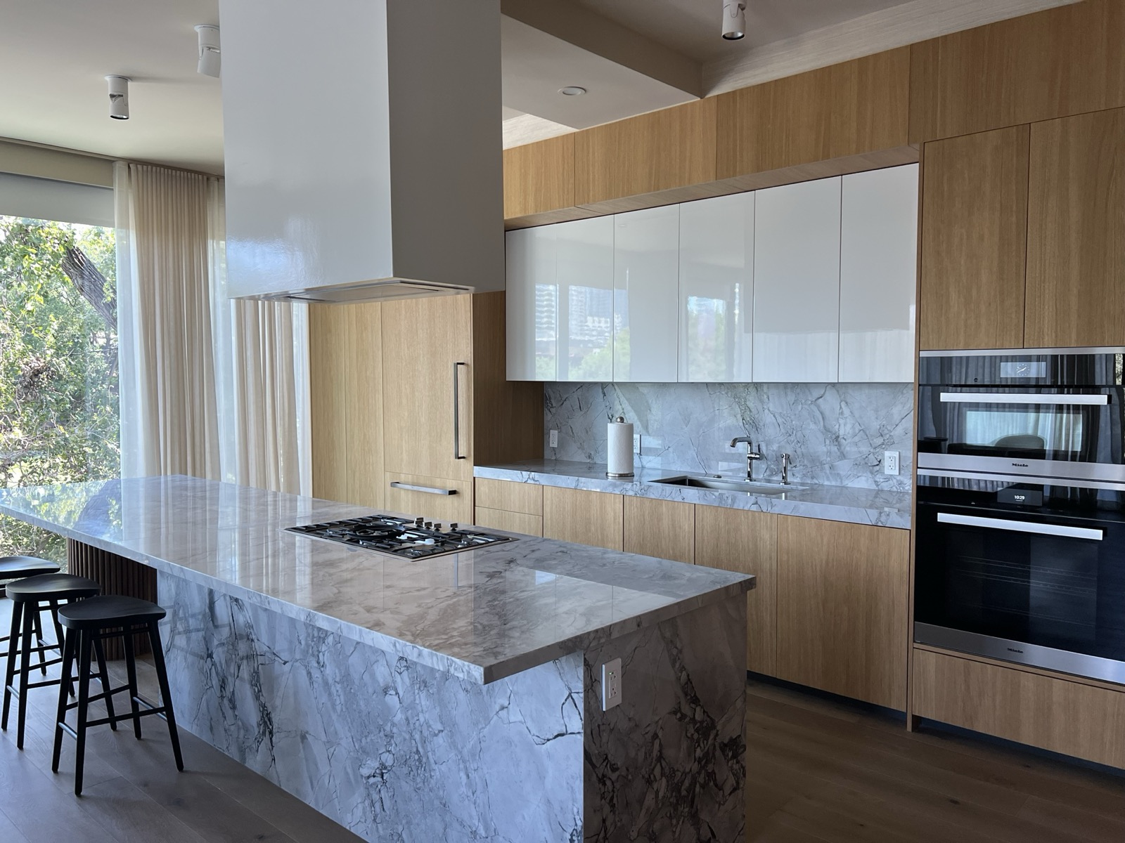 Downtown Austin condo kitchen with layered lighting and sheer drapes, installed by Bennett Technologies