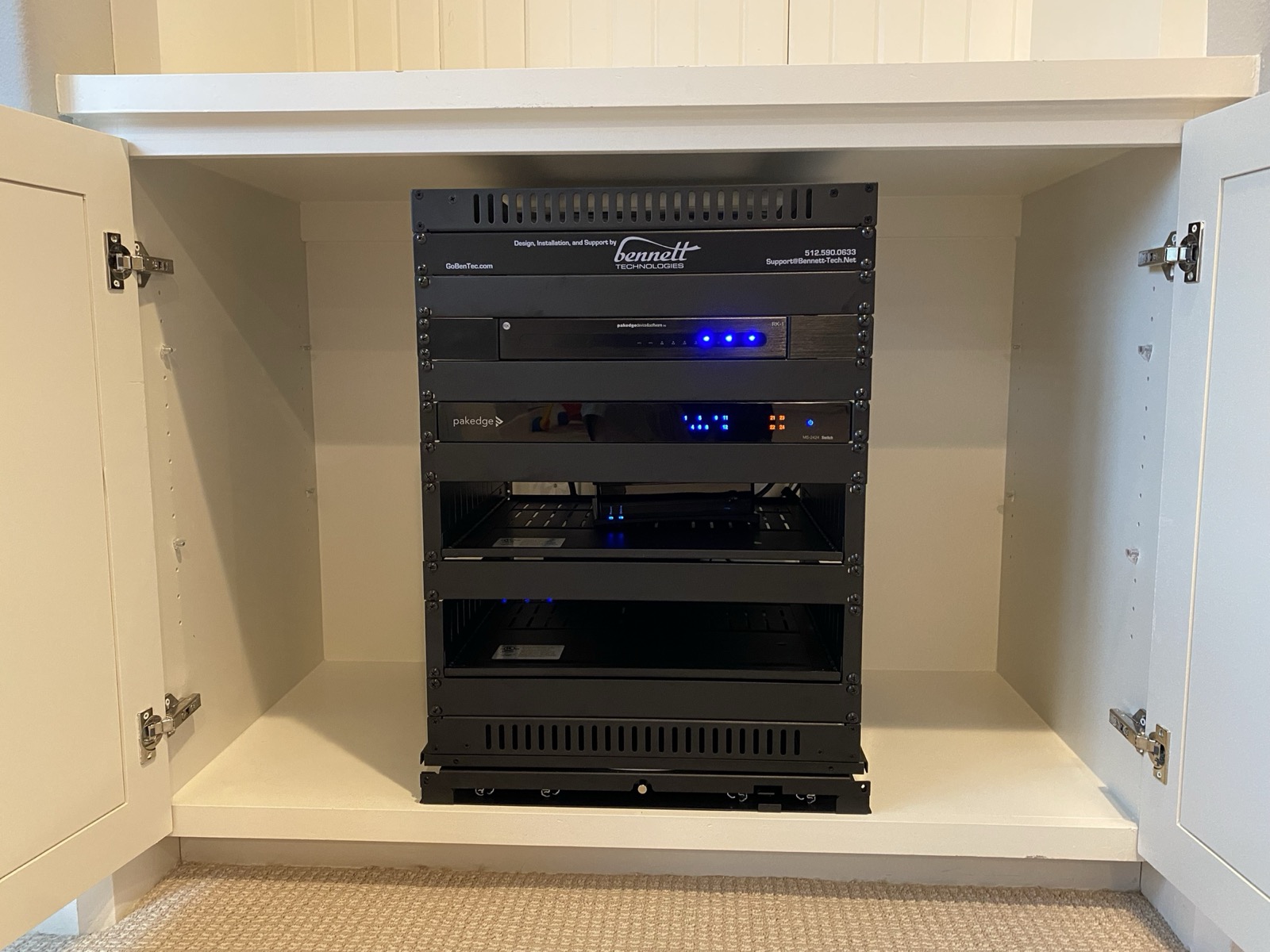 Compact network rack installed inside a white built-in cabinet in a Central Texas home