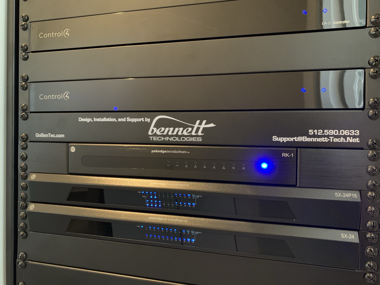 Bennett Technologies branded equipment rack with Control4 controllers and a Pakedge router and switches