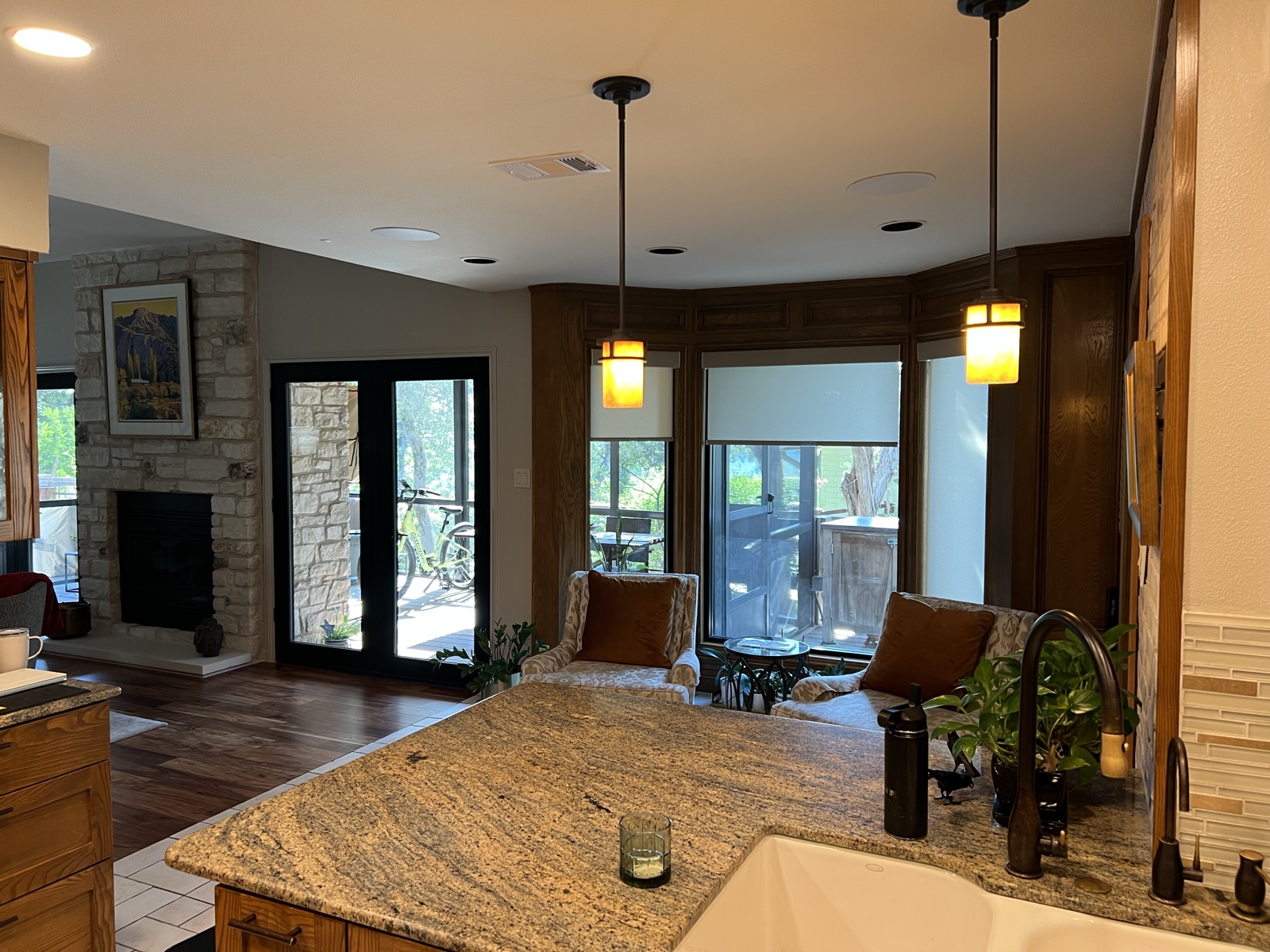 The kitchen island looking toward the great room, with pendant lights and in-ceiling speakers overhead