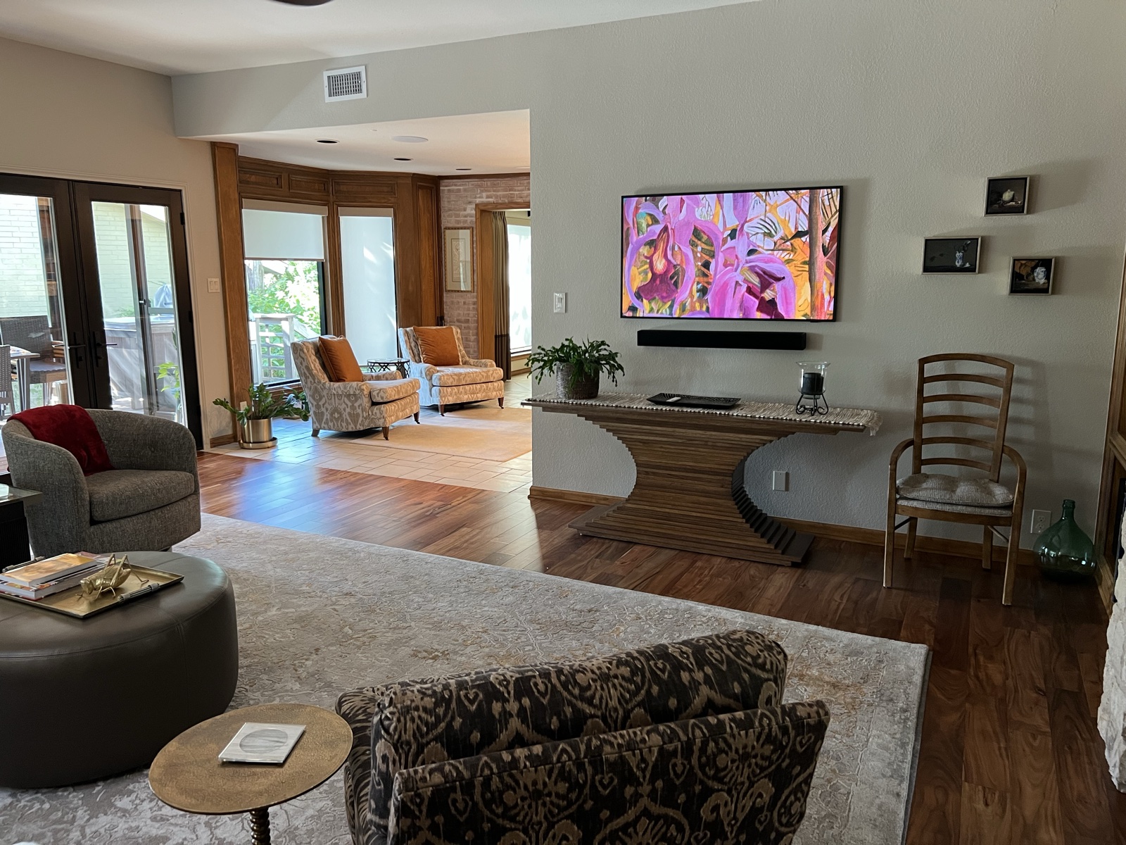 The living room with the Frame display on the wall, looking through to the sitting area and patio doors