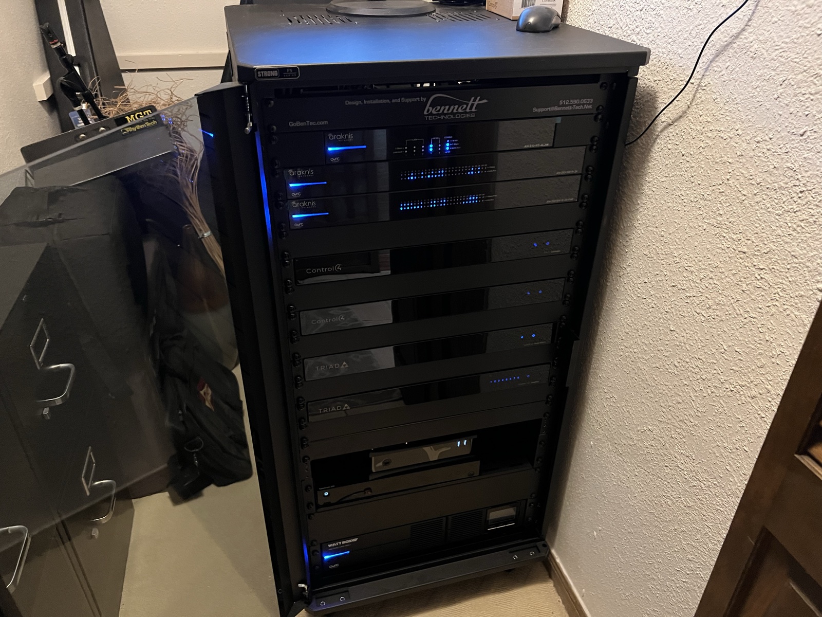 The rebuilt equipment rack in its closet, loaded with network switches, Control4 controllers, and Triad amplifiers