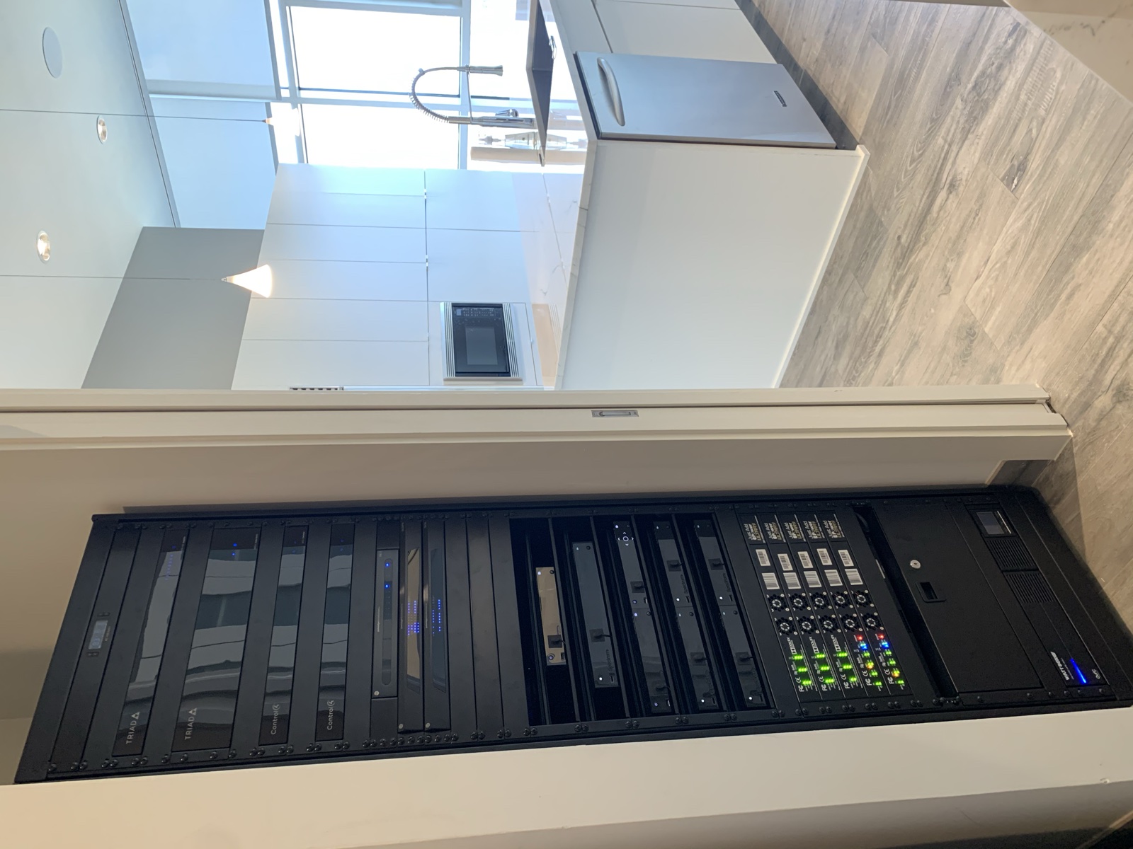 The full-height 42U equipment rack in its utility closet, with the kitchen beyond