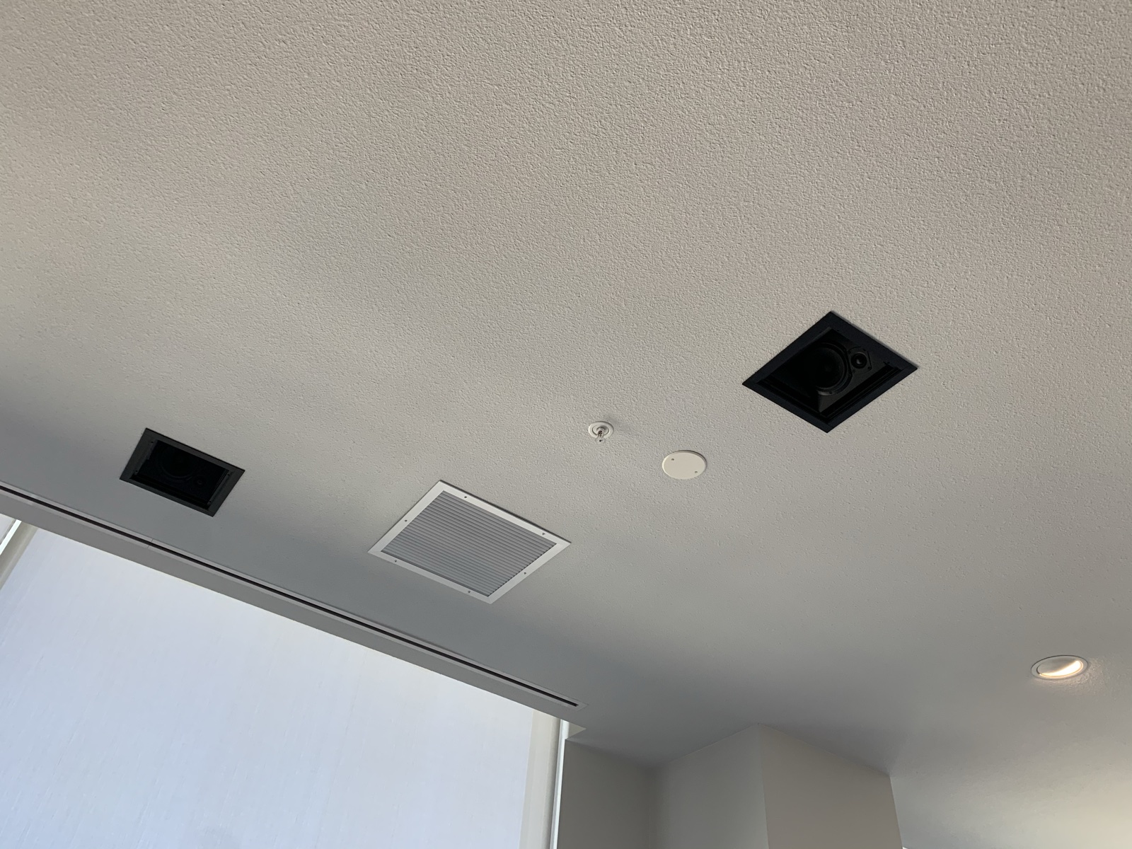 In-ceiling surround speakers for the family room system, set into the ceiling near the window wall