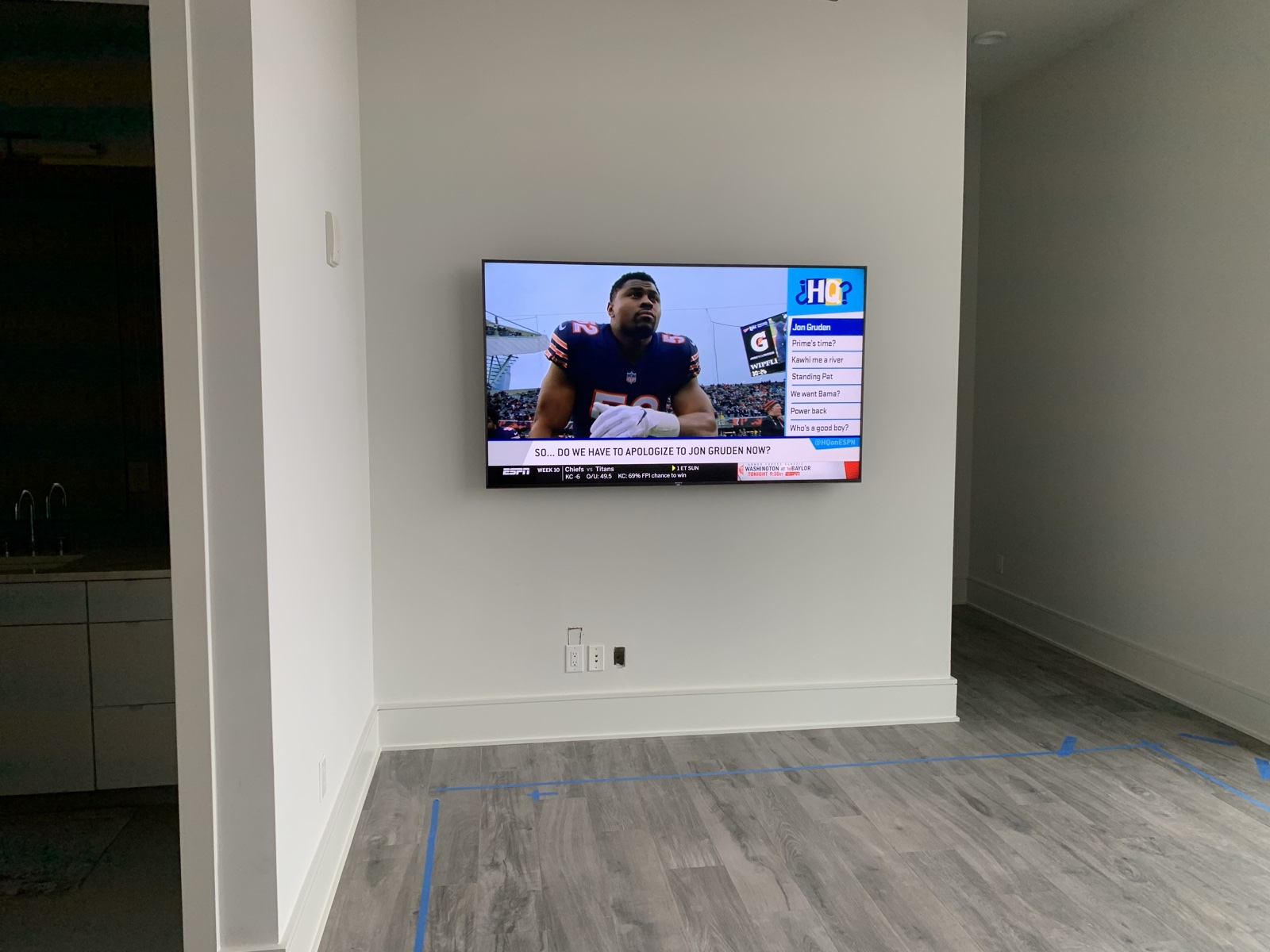 The guest bedroom TV wall-mounted during the remodel, floor protection still down