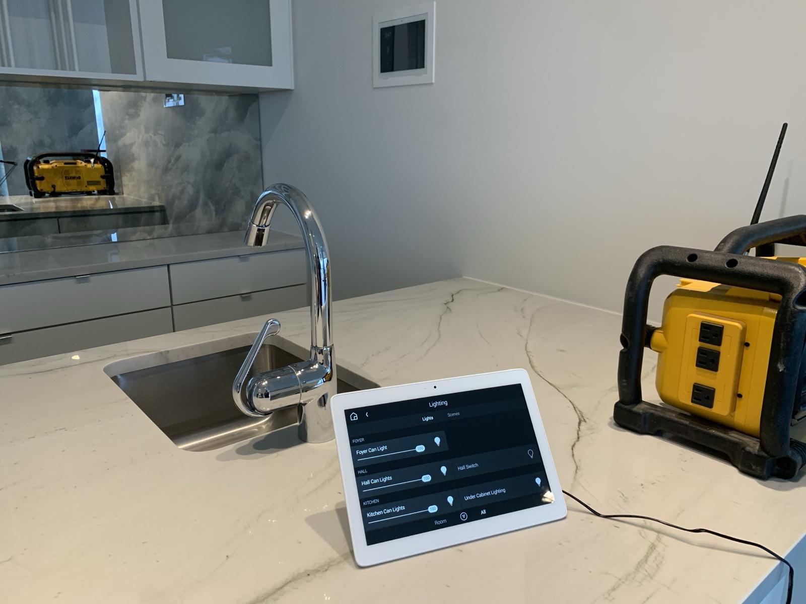 The portable tabletop touch screen on the kitchen island, showing lighting control during the install