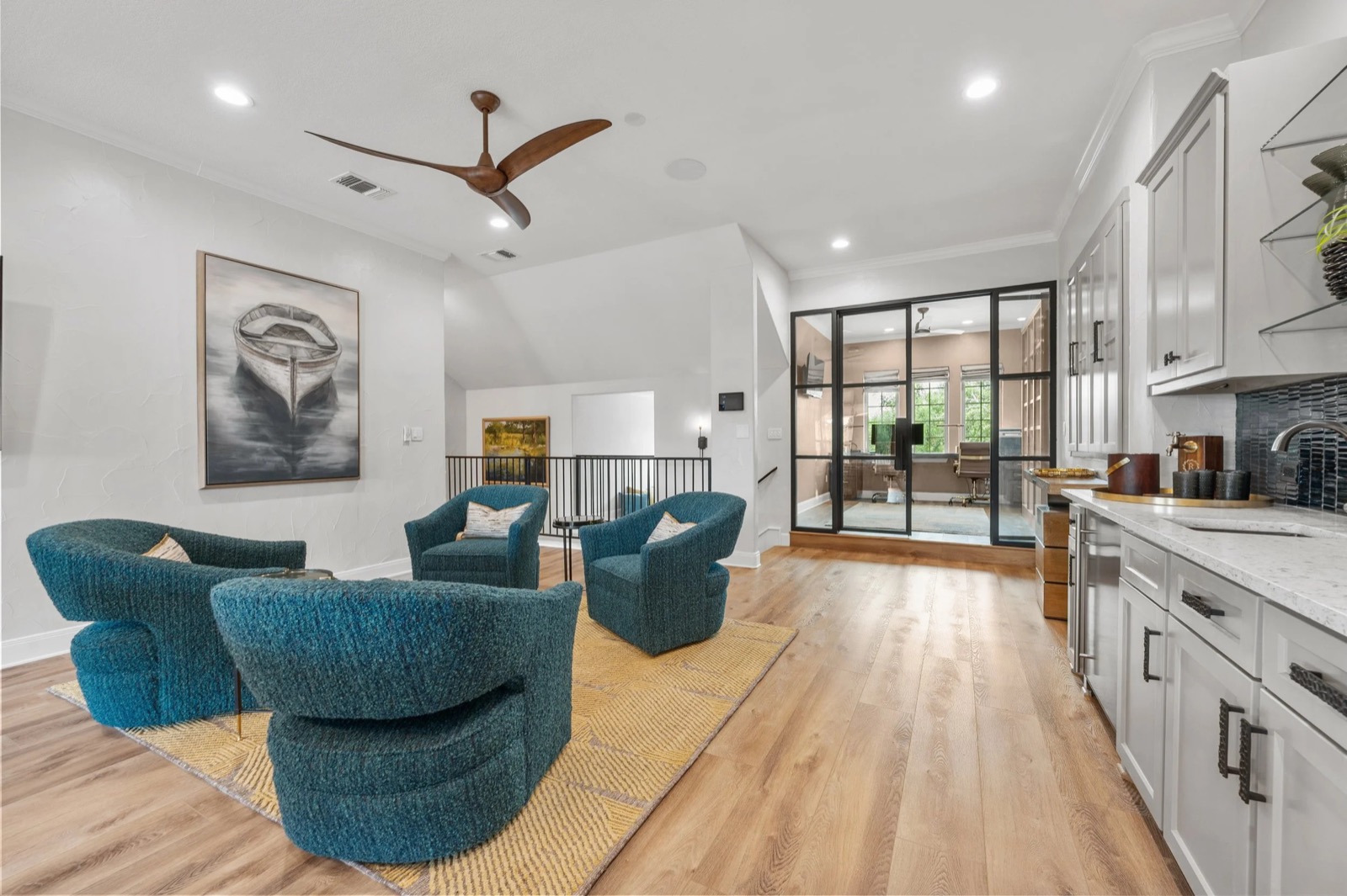 Upstairs loft at the Kingsland residence, with swivel chairs and the glass-walled office beyond