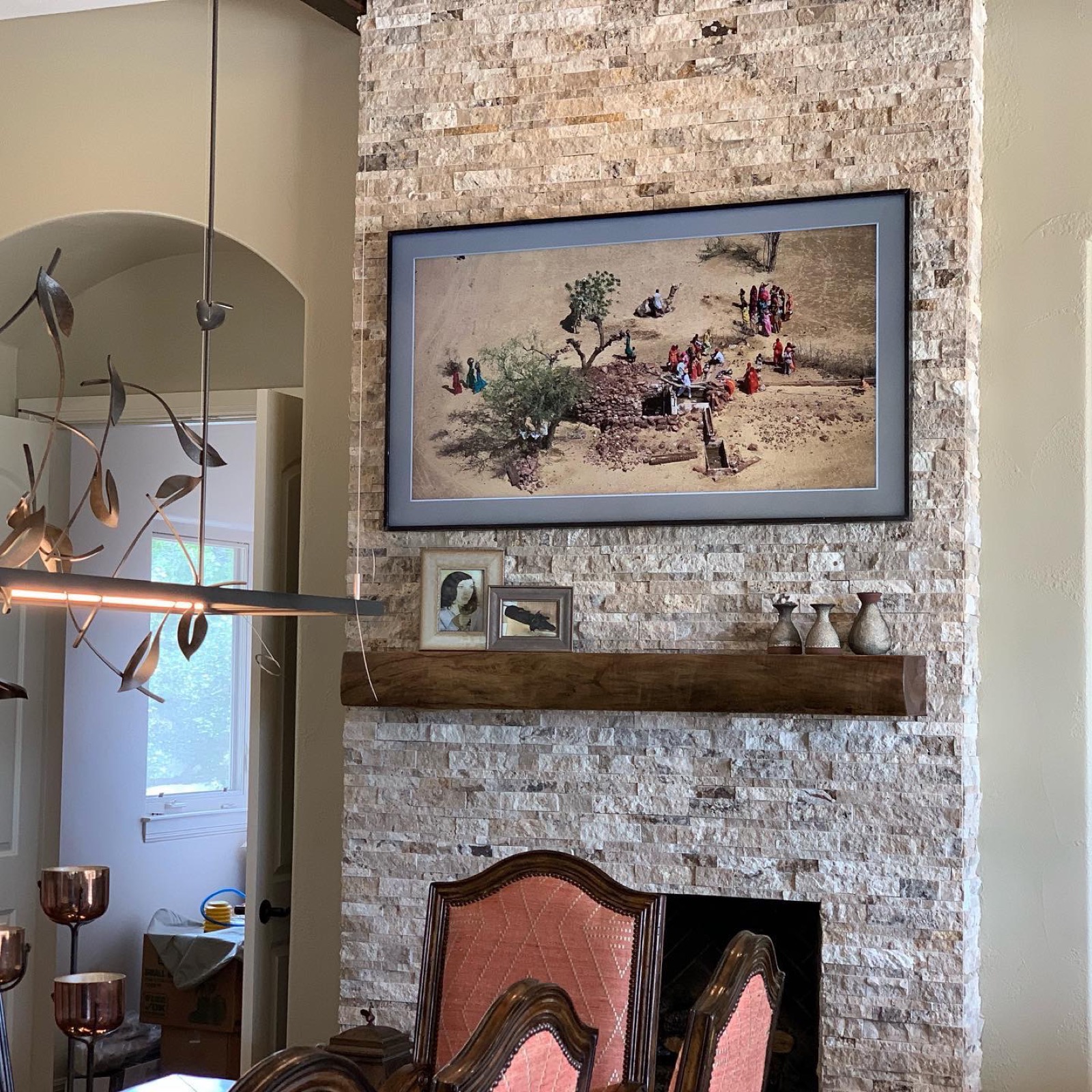 A Samsung Frame display showing art on a stone column at the Lake Travis estate