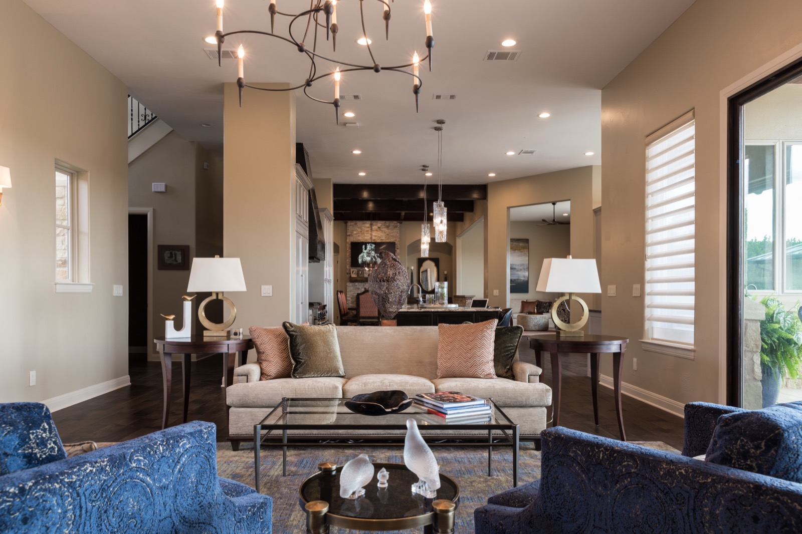 Great room at the Lake Travis estate with concealed whole-home audio and layered lamp light, open to the kitchen