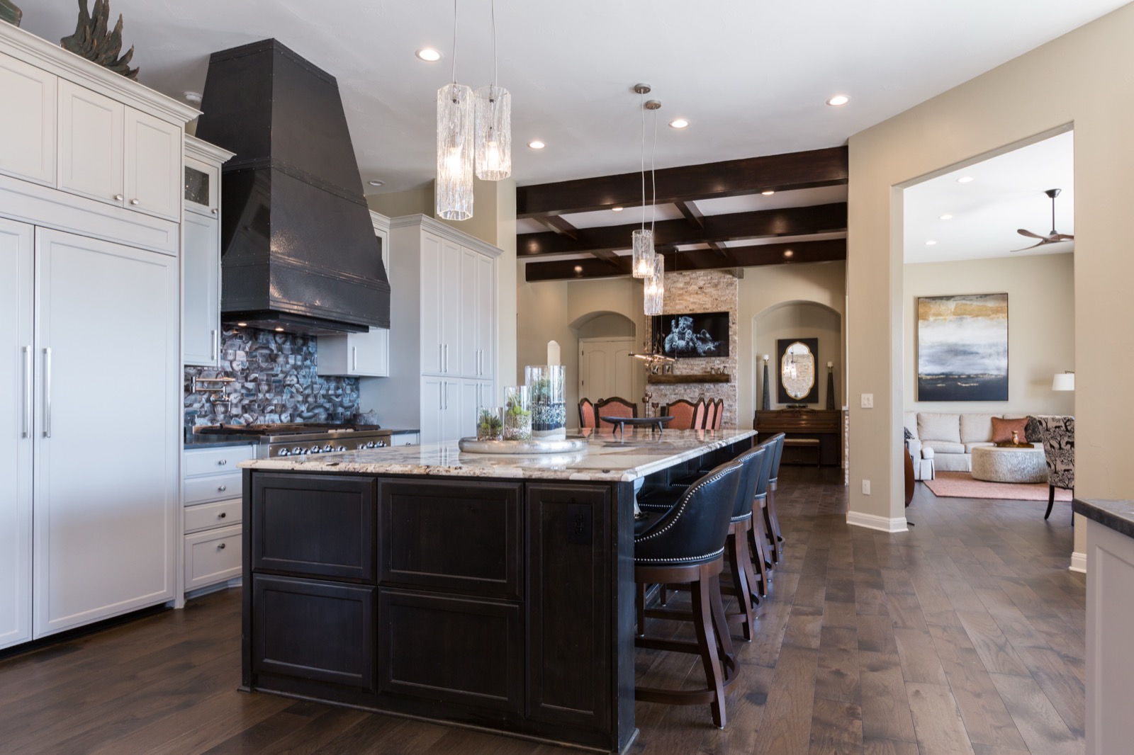 Kitchen at the Lake Travis estate with a large island, range hood, and bar seating, open to the dining room