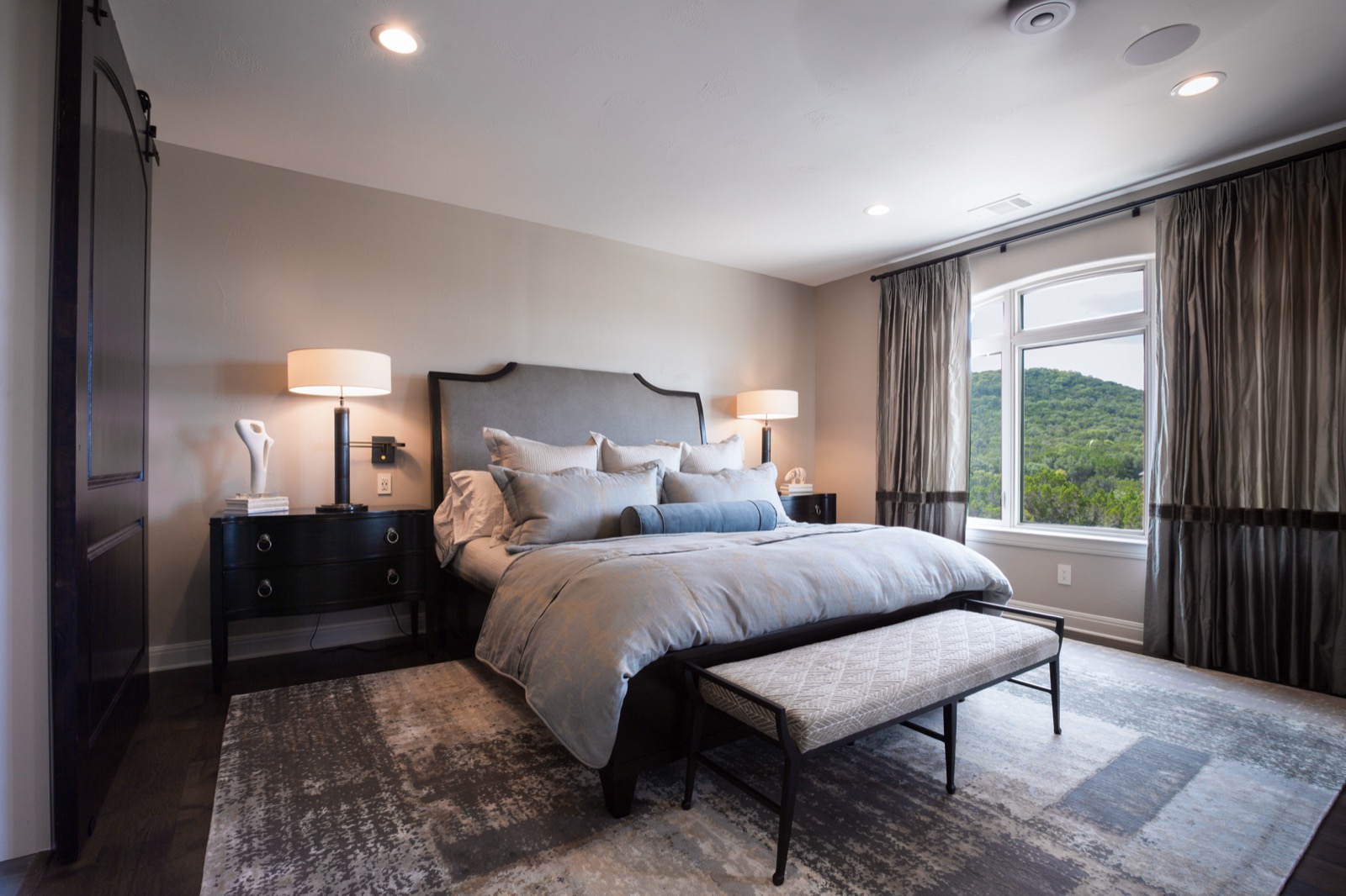 Master bedroom with in-ceiling speakers and a hill country view