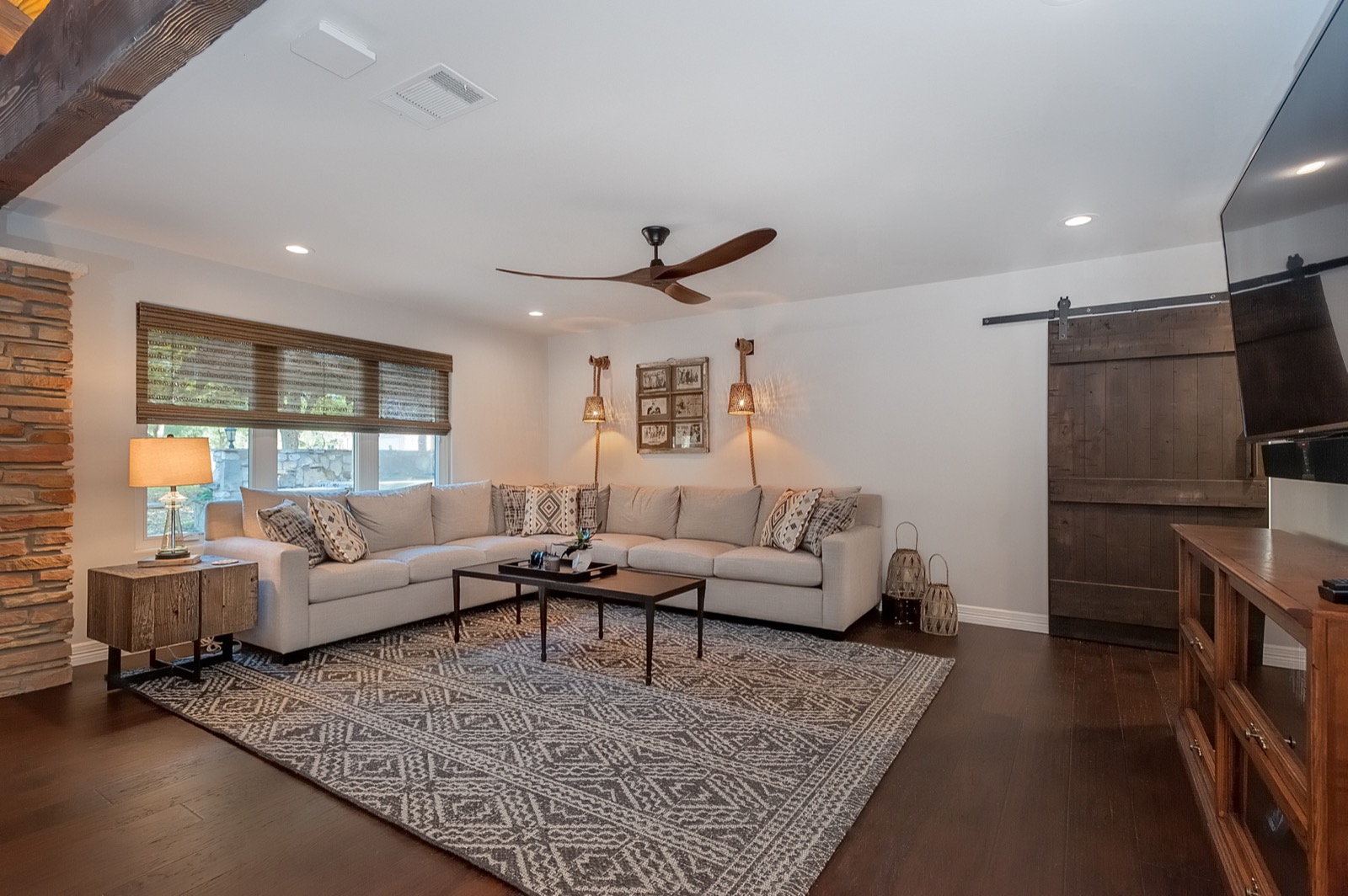 Family room at the Marble Falls retreat with a wall-mounted TV, an in-ceiling speaker, and sectional seating