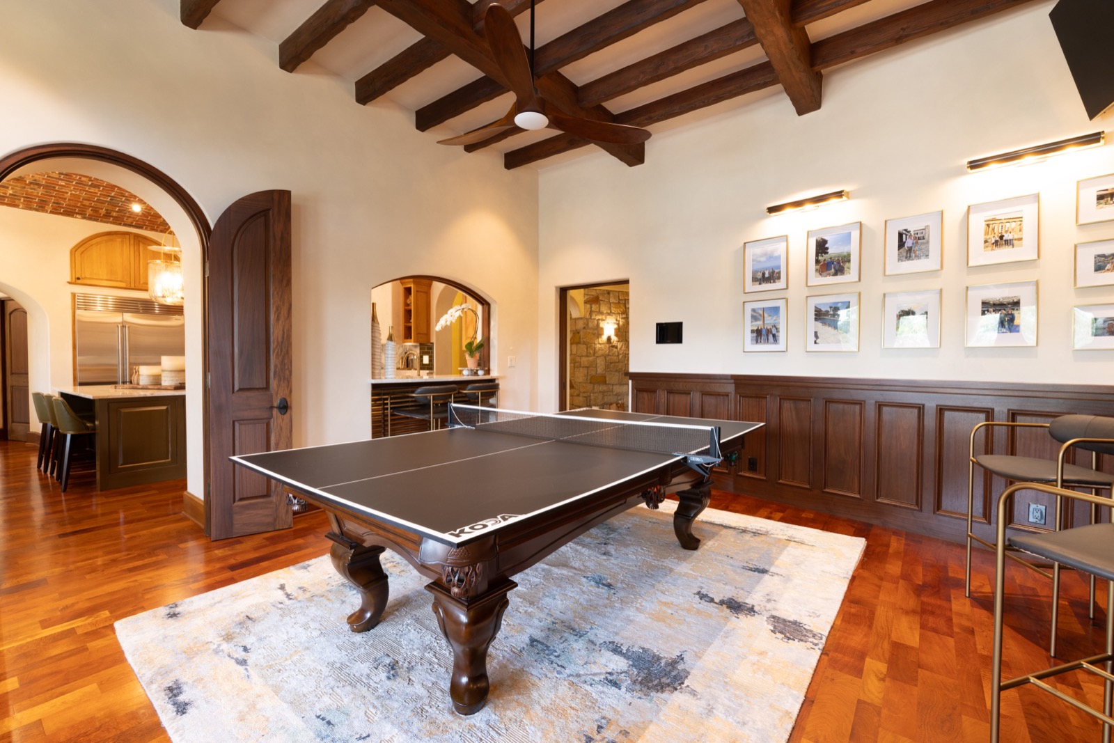 Game room with an in-wall touch screen beside the kitchen bar