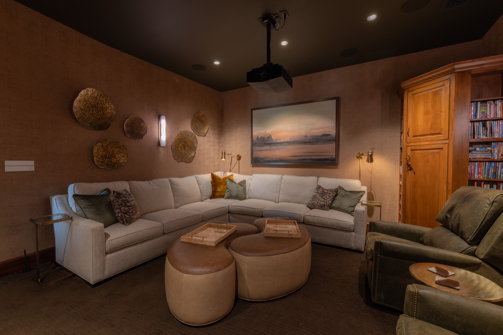 A media lounge at the Northwest Austin home with a ceiling projector and sectional seating