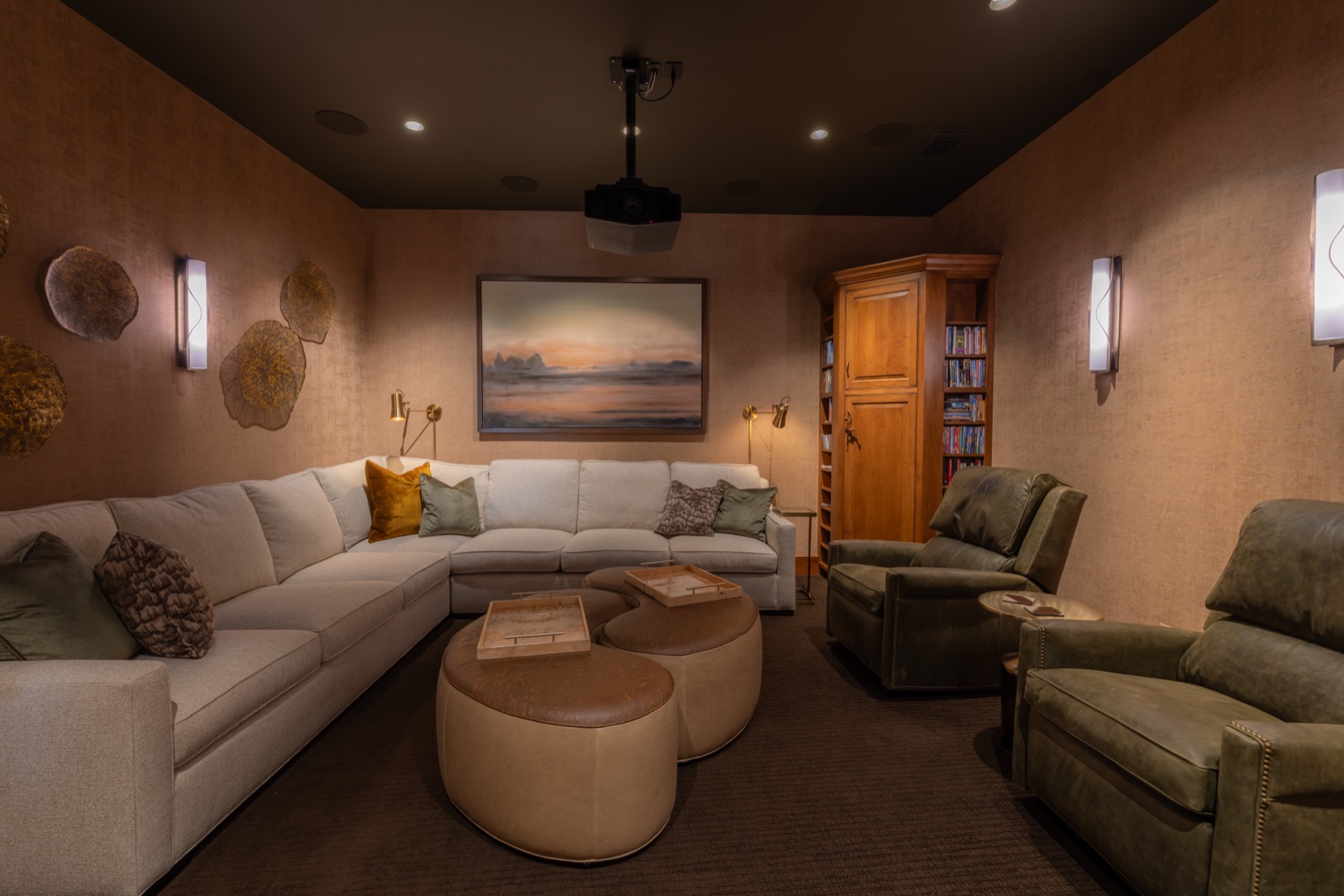 Remodeled home theater with laser projector and speakers blended into the walls and ceiling
