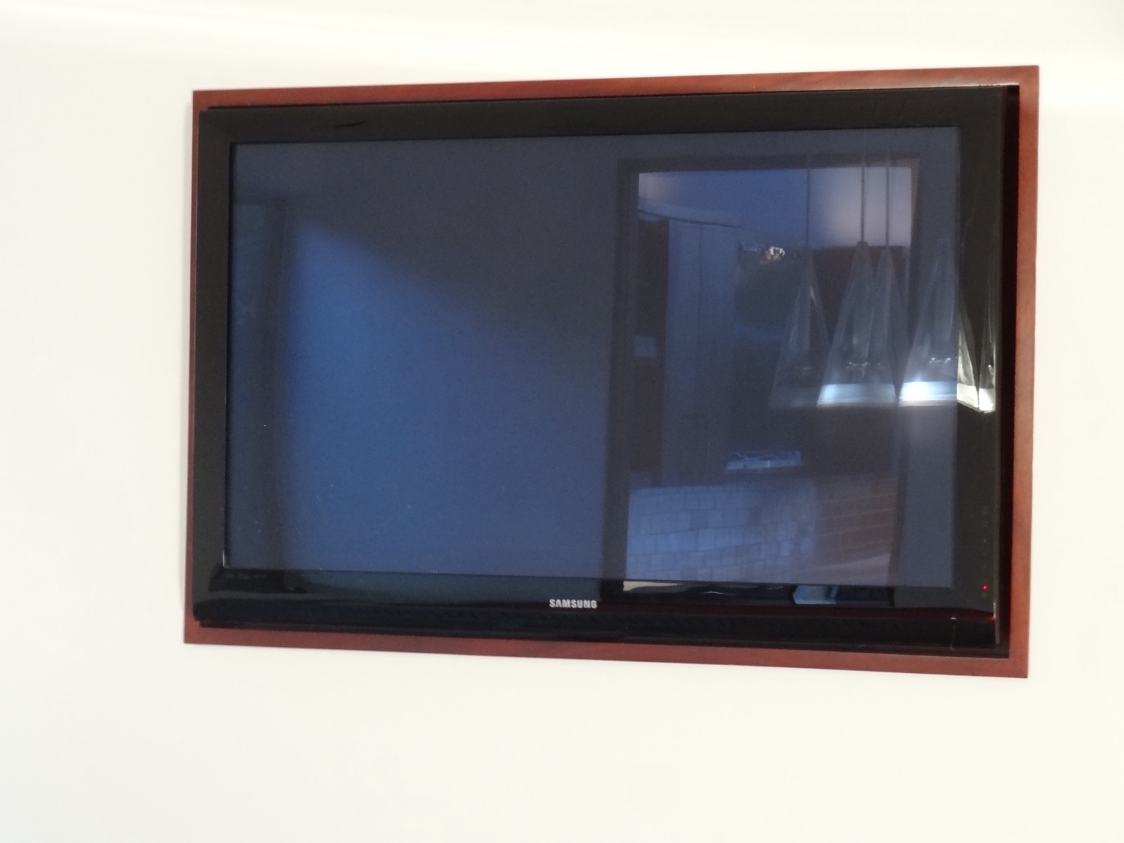 Flat screen display framed in mahogany millwork against the pavilion white walls