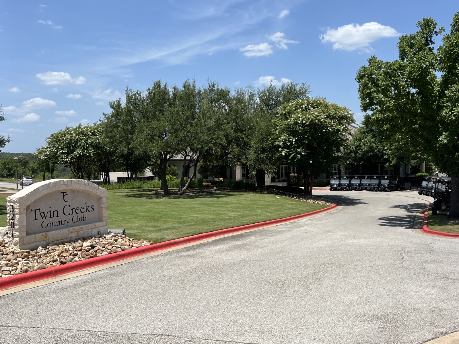 Twin Creeks Country Club entrance drive in Cedar Park with the clubhouse behind
