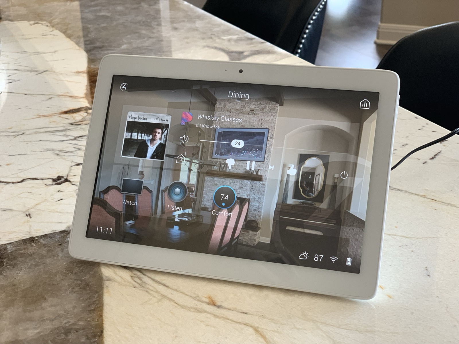 Control4 touchscreen on a kitchen counter showing dining room music, video, and climate control