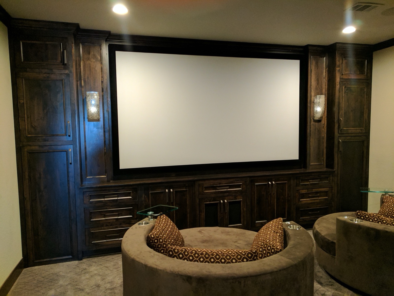 Dedicated home theater with dark wood built-ins and a projection screen, Austin TX