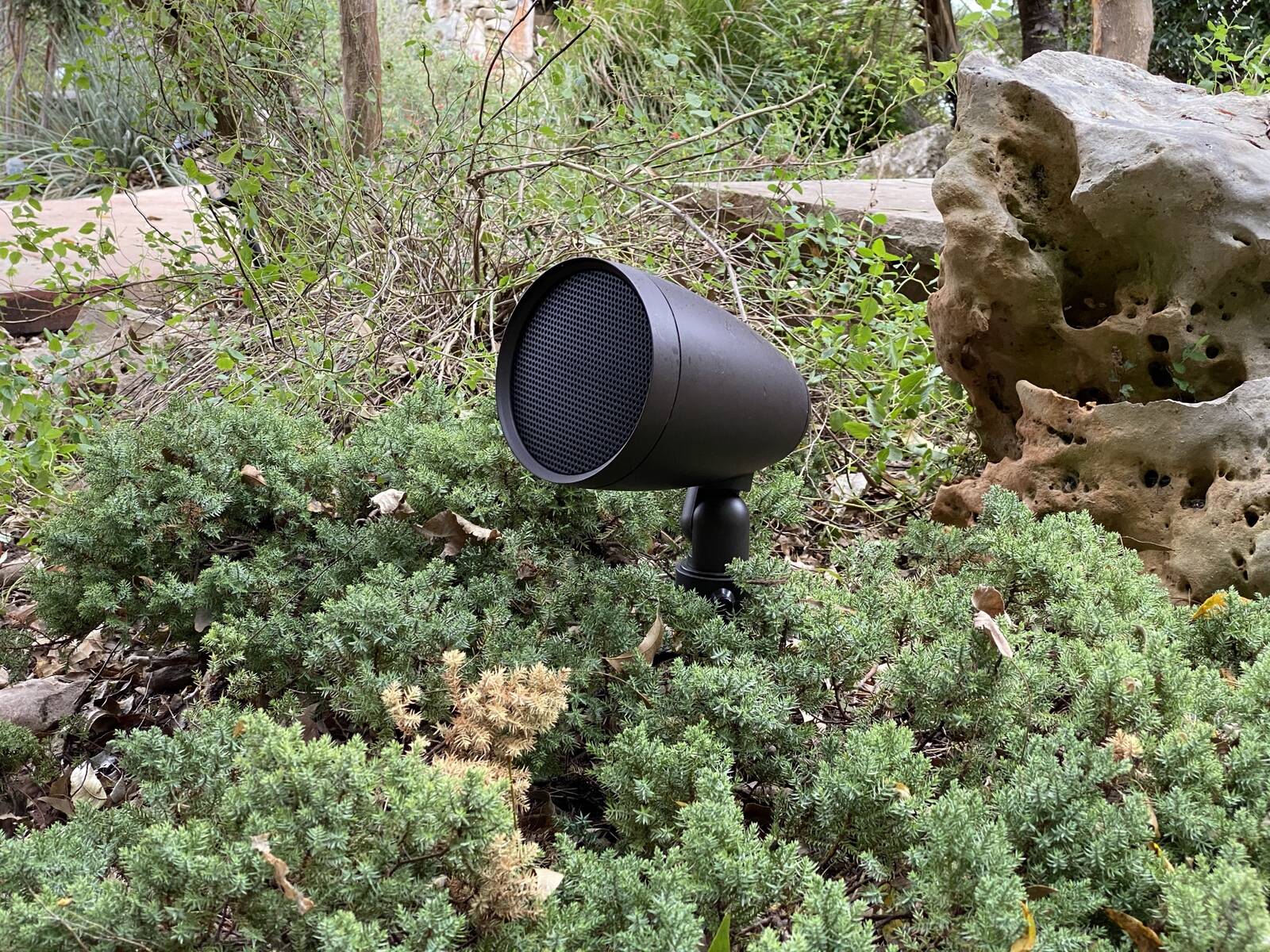 Landscape speaker set into a garden bed among the plantings