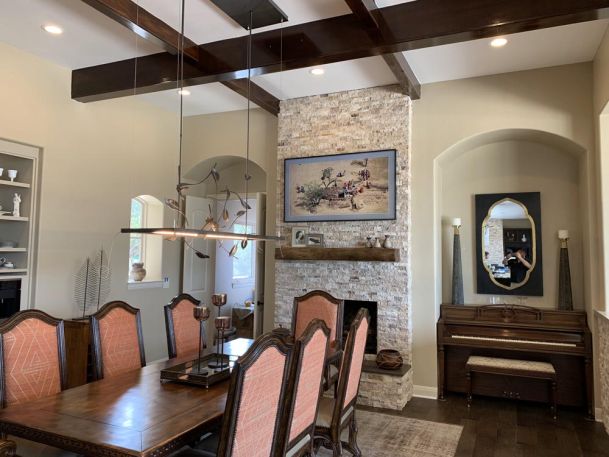 TV with art mounted on wall by wooden dining table