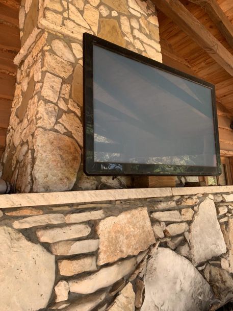 TV mounted on stone wall outdoors