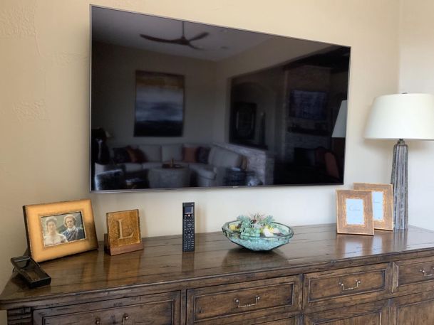 TV mounted on wall over wooden furniture